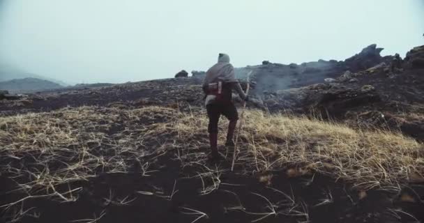Hooded Man wandelen over zwart zand — Stockvideo