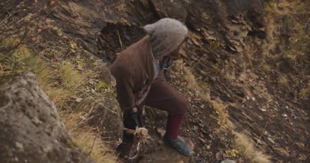 Kapucnis férfi sétál fel a domboldalra — Stock videók