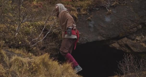 Homem encapuzado encontrando e entrando na caverna — Vídeo de Stock