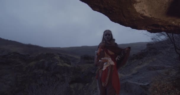 Mulher entrando na caverna do lit do fogo no crepúsculo — Vídeo de Stock