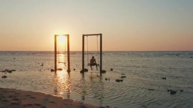 Denizde Gün Batımında Sallanan Adam