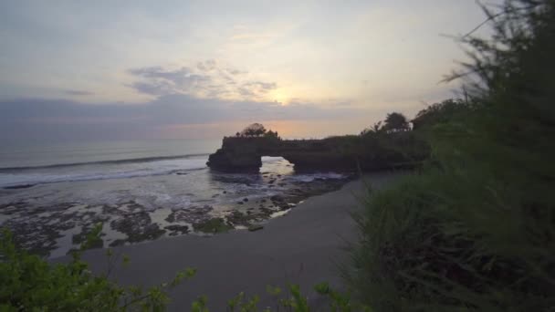 Pohled na pláž a Pura Batu Bolong na skalnatém výběžku — Stock video