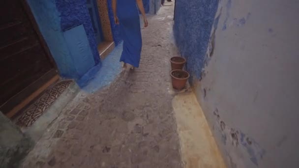 Kvinna i blå klänning promenader i Kasbah av Udayas — Stockvideo
