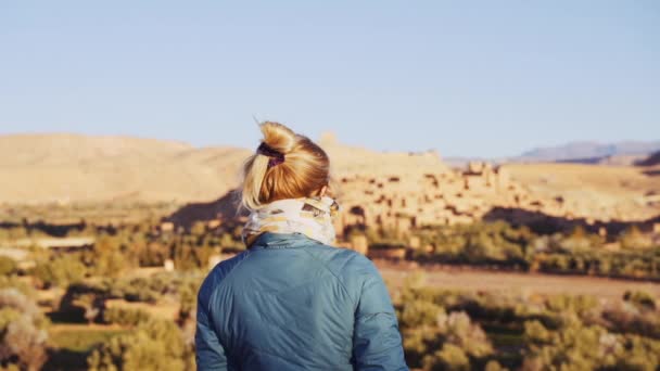 Tourist in der Wüste und mit Blick auf Ait Benhaddou — Stockvideo