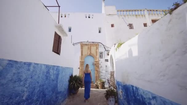 Blond vrouw in blauwe jurk in Kasbah van de Udayas — Stockvideo