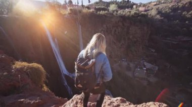 Ouzoud Falls 'un yanındaki uçurumun kenarındaki turist.