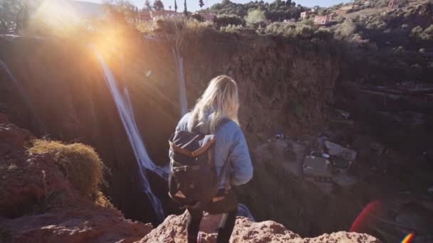 Turista em Cliff Edge na luz do sol ao lado de Ouzoud Falls — Vídeo de Stock