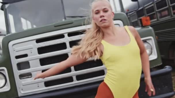 Blond dansare i rutin framför bussen — Stockvideo