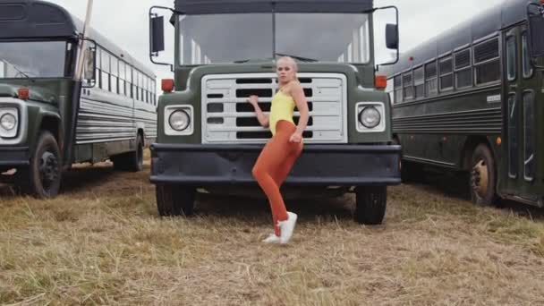 Jeune femme dansante en jaune devant le bus — Video