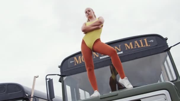 Молодая женщина в трико, стоящая в автобусной шапочке — стоковое видео