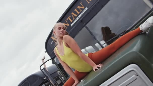 Молодой танцор в желтом играет в автобусе — стоковое видео