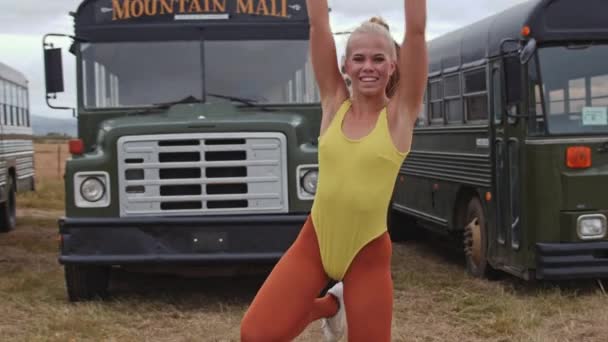 Menina em amarelo realizando dança na frente do ônibus — Vídeo de Stock