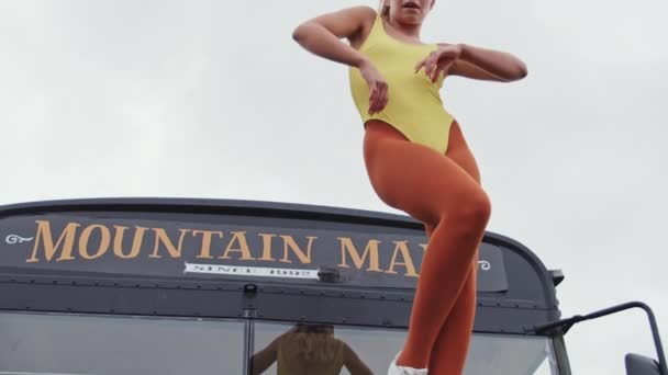 Γυναίκα χορεύει στο κίτρινο στην κορυφή του λεωφορείου — Αρχείο Βίντεο