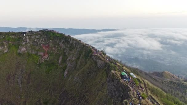 Drone nad turystami na stromym grzbiecie góry Batu — Wideo stockowe