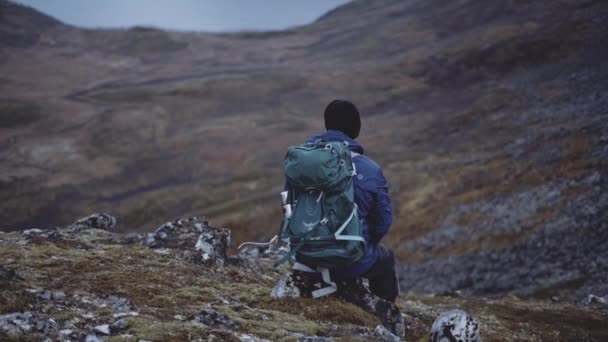 Пішохід з рюкзаком відпочиває в горах — стокове відео
