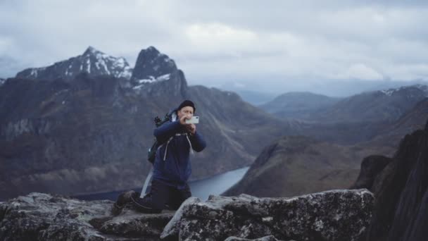 Турист со смартфоном в горном ландшафте — стоковое видео