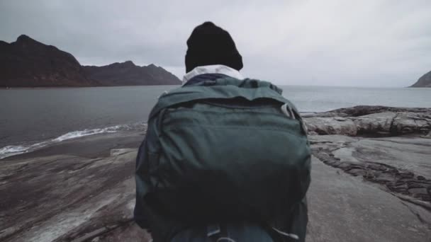 Caminante pisando rocas por fiordo — Vídeos de Stock