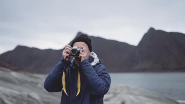 Wanderer fokussiert Slr-Kamera am Fjord — Stockvideo