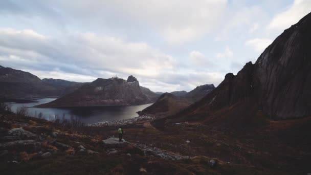 Wandelaar staand op rots kijkend naar Fjord en bergen — Stockvideo