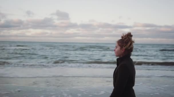 Menina em preto andando ao longo da praia — Vídeo de Stock