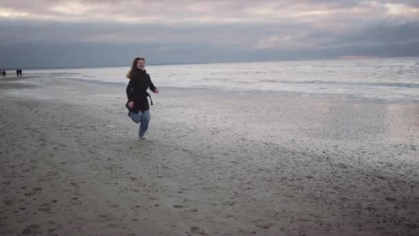 Röd tonåring flicka i svart vinka på stranden — Stockvideo