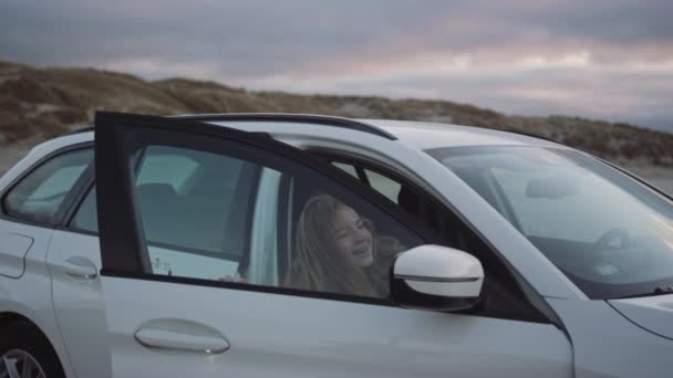 Teenager steigt am Strand aus Auto — Stockvideo