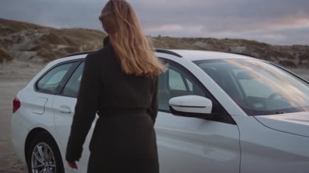 Pelirroja chica llegar en a coche en playa — Vídeo de stock