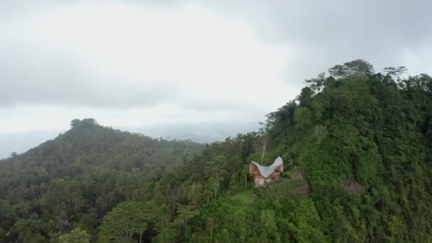 Над отдаленной постройкой в лесу кружат дроны — стоковое видео