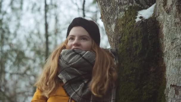 Уставшая девочка-подросток зимой, опирающаяся на дерево — стоковое видео