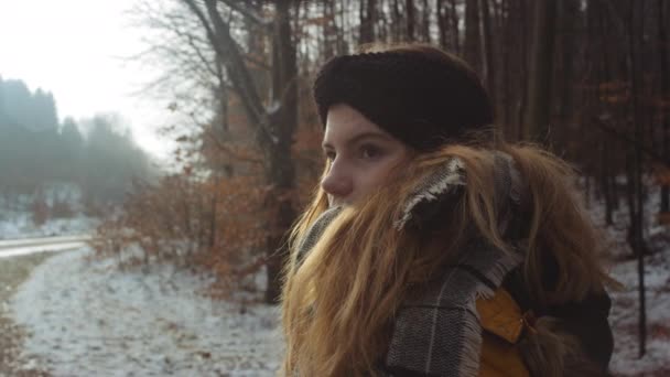 Menina adolescente olhando ao redor na floresta de inverno — Vídeo de Stock