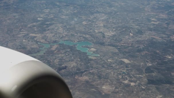 Літак летить над ландшафтом з зеленим озером — стокове відео