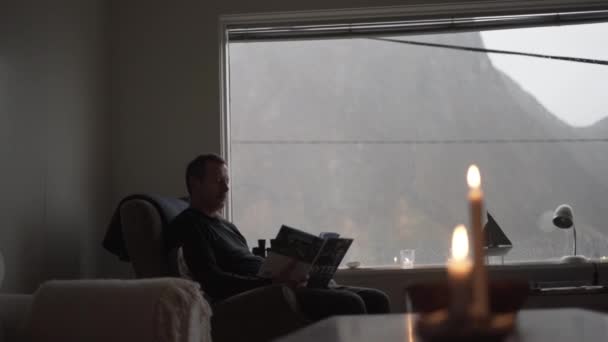 Mann entspannt sich im Sessel neben Blick auf Fjord — Stockvideo