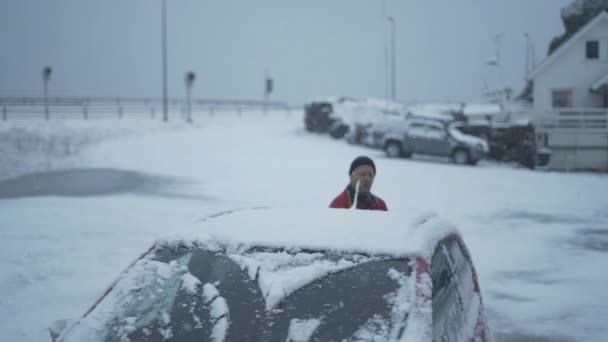 Man i röd clearing snö från bilen — Stockvideo