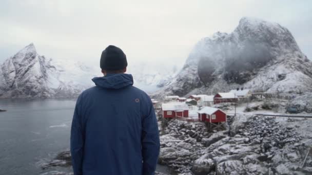 Man By Hamnoy Fishing Village With Olstinden Mountain — Stock Video