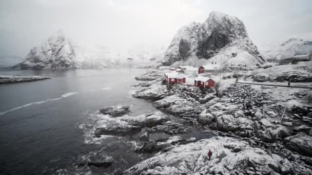 Turista v ledu a sněhu podle Hamnoy rybářské vesnice — Stock video