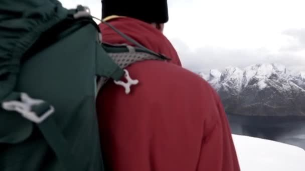 Retkeilijä kävelee luminen Mountain Peak Lofoten — kuvapankkivideo