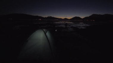 Alacakaranlıktaki Donmuş Riverside 'da Aydınlanmış Çadır