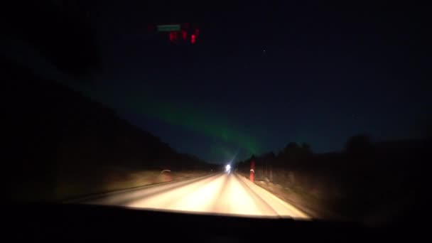 Caminhões passam na estrada com luzes do norte — Vídeo de Stock