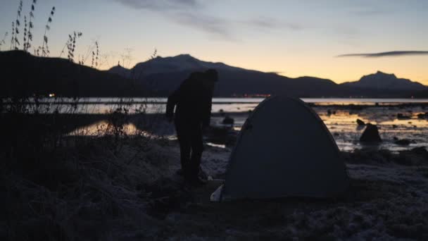 Man opzetten van tent dicht bij de rivier in de winter — Stockvideo