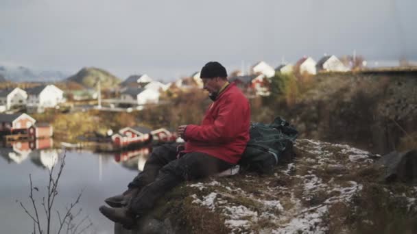 Odpočívající pěší túra na skále u Reine Village — Stock video