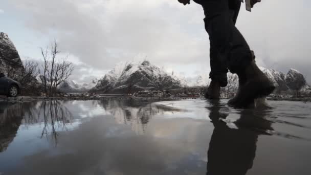 Wandelaar wandelen door het water te Reine — Stockvideo
