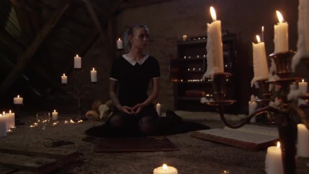 Young Woman Kneeling In Attic Of Lit Candles — Stockvideo
