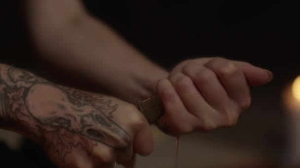 Tattooed Woman Using Knife To Cut Palm Of Other Hand — Stockvideo