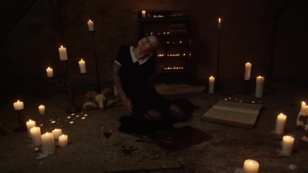 Woman Twisting And Writhing On Candle Lit Attic Floor — Stock Video