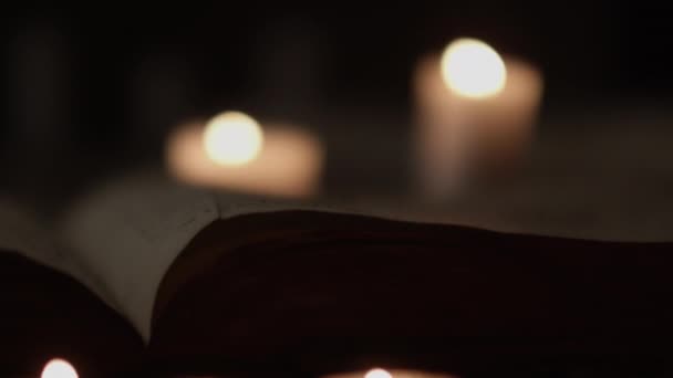 Pages And Lit Candles Being Blown Out By Wind In Dark Room — Stock Video