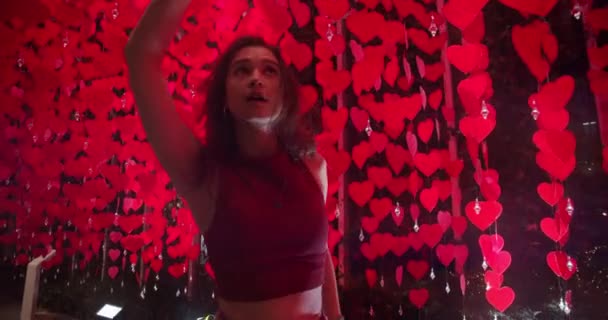 Bailarina moderna pasando por la cortina roja del corazón en la habitación tenue — Vídeos de Stock