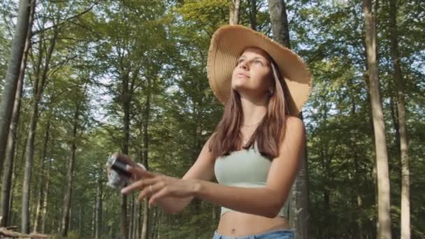 Adolescente utilisant un vieil appareil photo dans la forêt — Video