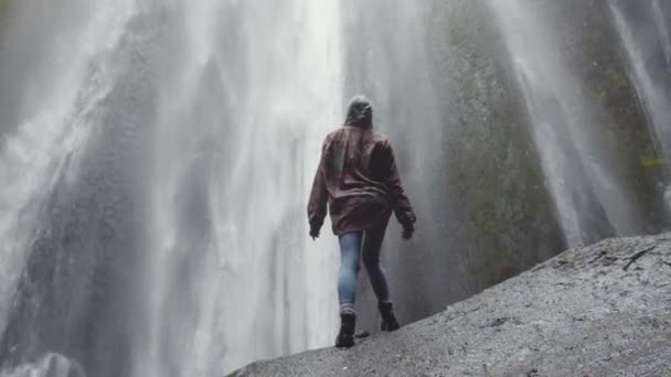 Donna in piedi sulla roccia vicino alla cascata — Video Stock