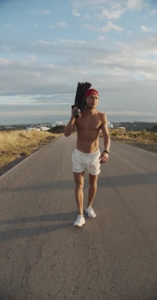 Mies kävelee pitkin tyhjää Sunlit Road — kuvapankkivideo