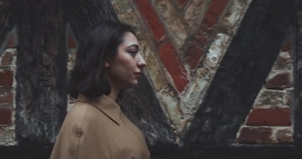 Mladá žena míjející staré městské budovy — Stock video
